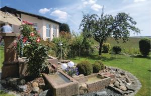 a garden in front of a house with a fountain at Cozy Apartment In Karlshausen With Wifi in Karlshausen