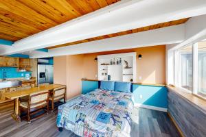 een slaapkamer met een bed en een keuken bij Seaside Serene in Port Orford