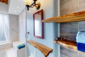 een badkamer met een spiegel en een houten plank bij Seaside Serene in Port Orford
