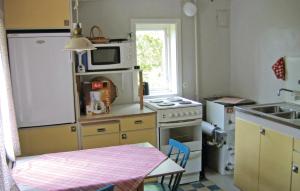 a small kitchen with a stove and a microwave at 2 Bedroom Nice Home In Fårösund in Fårösund