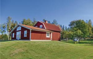 uma casa vermelha num campo com relva em Beautiful Home In Orrefors With Lake View em Orrefors