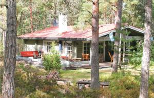 a house with a red roof in the woods at Cozy Home In Hammar With Sauna in Hammarö