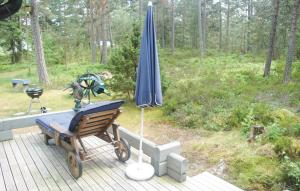a blue umbrella and a bench on a deck at Cozy Home In Hammar With Sauna in Hammarö
