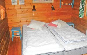 een bed in een houten kamer met 2 lampen en een stoel bij Cozy Home In Hammar With Sauna in Hammarö