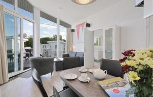 a dining room and living room with a table and chairs at Dnenvilla Penthouse Superior in Priwall