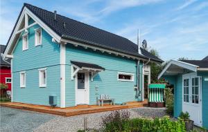 ein blaues Haus mit einer Holzterrasse in der Unterkunft Seeliebe 3 in Süssau