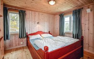 a bedroom with a red bed in a room with wooden walls at Lovely Home In Hemsedal With Wifi in Hemsedal