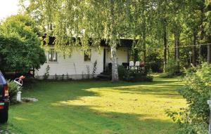 una casa con un árbol en el patio en Amazing home in Sparreholm with 5 Bedrooms, Sauna and WiFi en Sparreholm