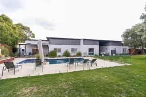 a house with a swimming pool and chairs in a yard at Inverloch Oasis L Oasi de Invy in Inverloch