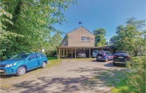 a house with two cars parked in front of it at Stunning Apartment In St Annen in Sankt Annen