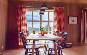 uma sala de jantar com uma mesa e cadeiras e uma janela em Moltebret em Skåbu