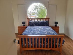 1 dormitorio con 1 cama y ventana grande en Beatons Beach Front Studio Inverloch, en Inverloch
