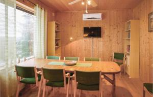 ein Esszimmer mit einem Holztisch und grünen Stühlen in der Unterkunft Hjorten in Fegen