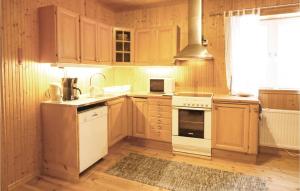 a kitchen with white appliances and wooden cabinets at Hjorten in Fegen