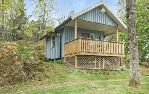 una pequeña casa verde con terraza en una colina en Beautiful Home In Bullaren With Kitchen, en Bullaren