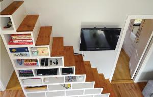 ein Wohnzimmer mit einer Treppe und einem TV in der Unterkunft 3 Bedroom Nice Home In Fjlkinge in Ivö