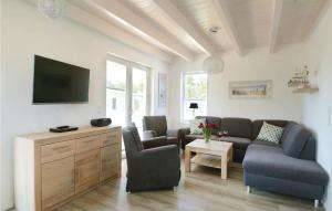 ein Wohnzimmer mit einem Sofa und einem TV in der Unterkunft Seerose 8 in Süssau