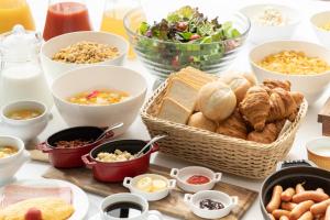 a table with various foods and bowls of food at Hotel The West Hills Mito in Mito