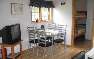 een eetkamer met een tafel, stoelen en een televisie bij Cozy Home In Visby With Wifi in Visby