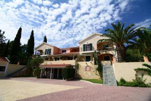 une grande maison avec un palmier en face dans l'établissement Residence Poseidon, à Spartià