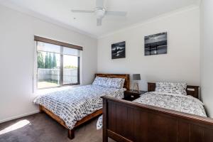 a bedroom with two beds and a window at Surfside Lakeviews Free Wifi in Inverloch