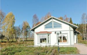 a small white house in the middle of a field at Holiday Home Östra Berga Lysvik in Lysvik