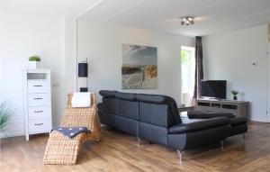 un salon avec un canapé noir et une télévision dans l'établissement Stunning Home In Vlagtwedde With Kitchen, à Vlagtwedde