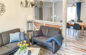 uma sala de estar com um sofá e uma cadeira em Beautiful Home In Norddeich With Kitchen em Norddeich