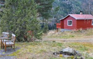 a red house and a bench next to a building at Heggebu in Vråliosen