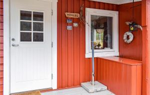 a red house with a white door and a window at Heggebu in Vråliosen