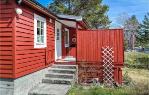 a red tiny house with stairs leading to the door at Heggebu in Vråliosen