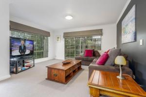 a living room with a couch and a tv at Ripple Dream Inverloch in Inverloch