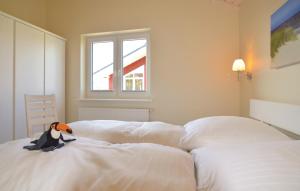 einem ausgestopften Pinguin auf einem Bett in der Unterkunft Beautiful Home In Dagebll With 2 Bedrooms, Sauna And Wifi in Dagebüll