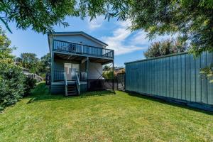 a house with a balcony and a fence at EAGLES NEST VIEWS ON TAMARA in Inverloch