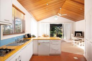 a kitchen with white cabinets and a wooden ceiling at Sails Two Inverloch in Inverloch