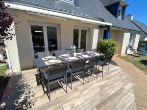 a dining table and chairs on a patio at Maison charmante proches plages - 9 pers. - jardin, vélos, calme - Arzon - FR-1-639-22 in Arzon