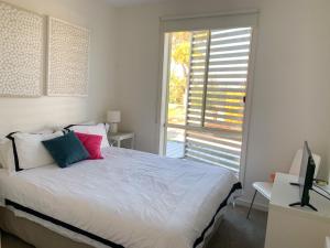 una camera da letto con un letto e una grande finestra di At Broadbeach Inverloch a Inverloch Altre 16 foto