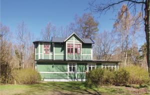 a green house with a black roof at Awesome Home In Ystad With Kitchen in Ystad