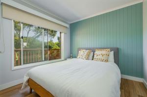 a bedroom with a large bed and a window at Hip Nautic 100 Metres to Beach in Inverloch