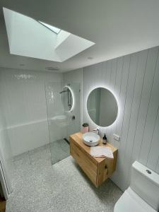 a bathroom with a sink and a mirror and a toilet at Hip Nautic 100 Metres to Beach in Inverloch