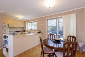 a kitchen and dining room with a table and chairs at Perfect on Pymble Ave in Inverloch