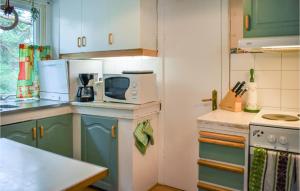 a kitchen with blue cabinets and a microwave at Holiday Home Yngsjö 49 in Yngsjö