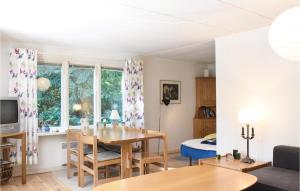LöderupにあるGorgeous Home In Lderup With Kitchenのリビングルーム(テーブル付)、ベッドルーム1室