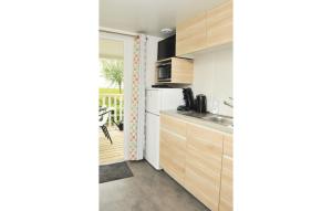 a kitchen with a sink and a refrigerator at Huisje Frisse Wind in Westerland