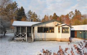 ein kleines weißes Haus im Schnee mit Bäumen in der Unterkunft Pet Friendly Home In Laholm With Kitchen in Plingshult