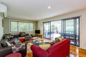 a living room with red furniture and a large window at Surfside Getaway in Picturesque Inverloch in Inverloch