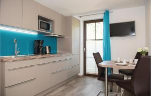 ラウリスにあるStunning Apartment In Rauris With 1 Bedrooms And Wifiのキッチン(白いキャビネット、テーブル、椅子付)