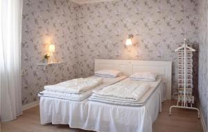 Södra ViにあるGorgeous Apartment In Sdra Vi With Kitchenのベッドルーム1室(ベッド2台付)、花の壁が備わります。