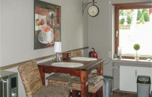 Habitación con mesa, sillas y reloj en la pared en Beautiful Apartment In Goslar With Kitchen, en Goslar