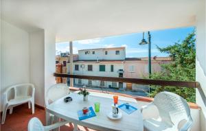 a balcony with a table and chairs and a large window at Trilo Sup in Isola Rossa